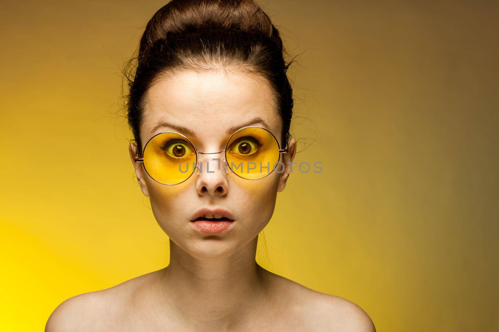 brunette with yellow glasses bare shoulders clear skin. High quality photo