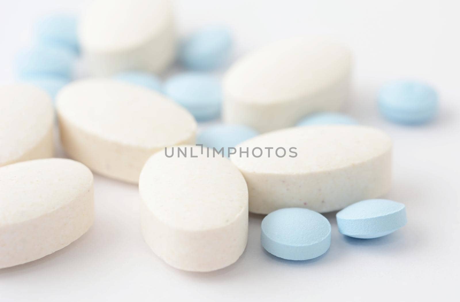 A close up of group of pills on white background.