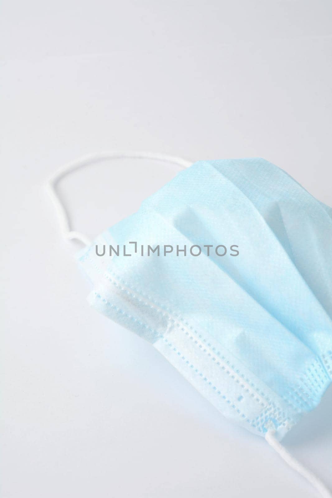 Blue surgical face mask on white background by hamik