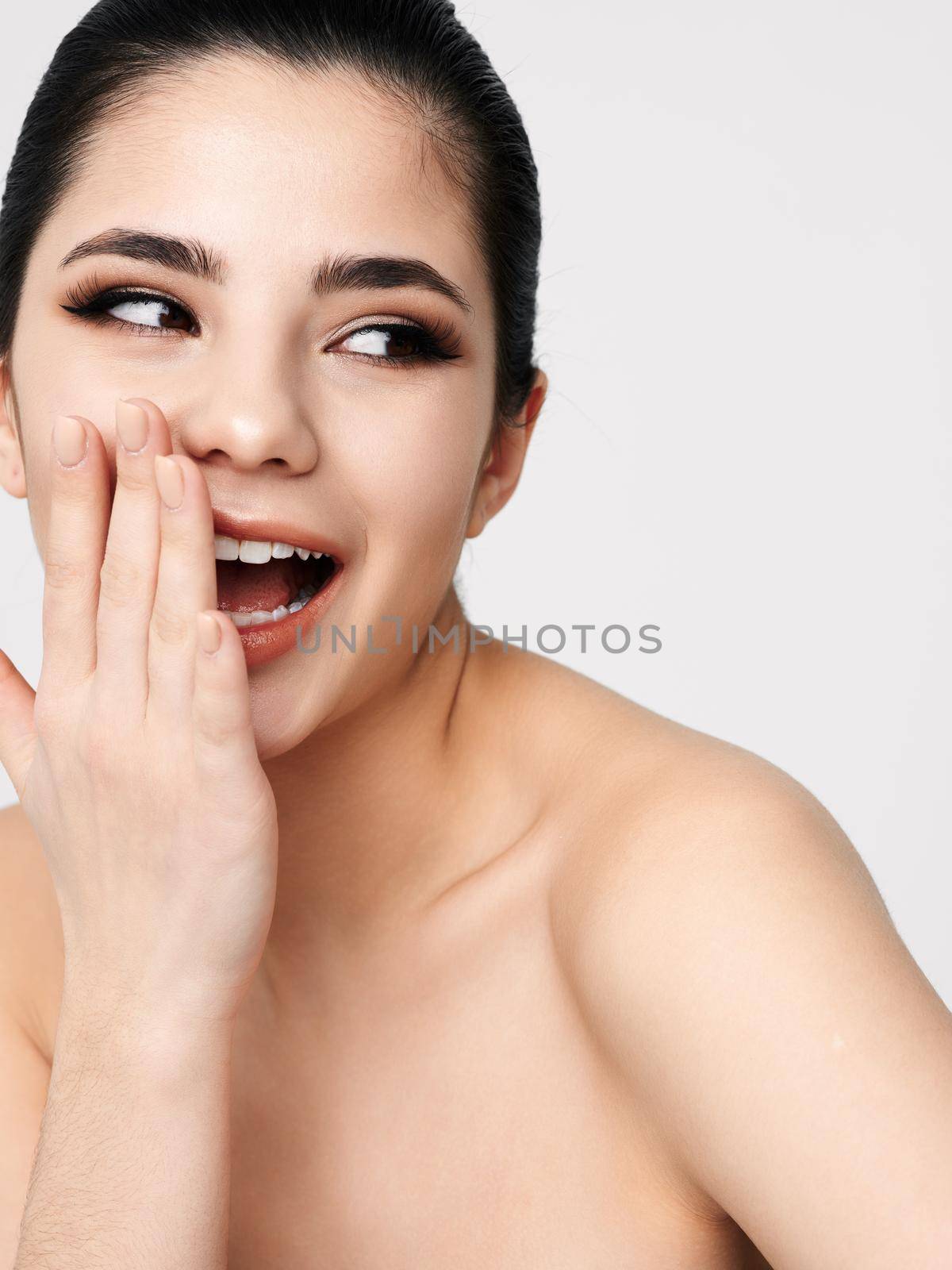 cheerful woman covers her face with her hand emotions bare shoulders close-up. High quality photo