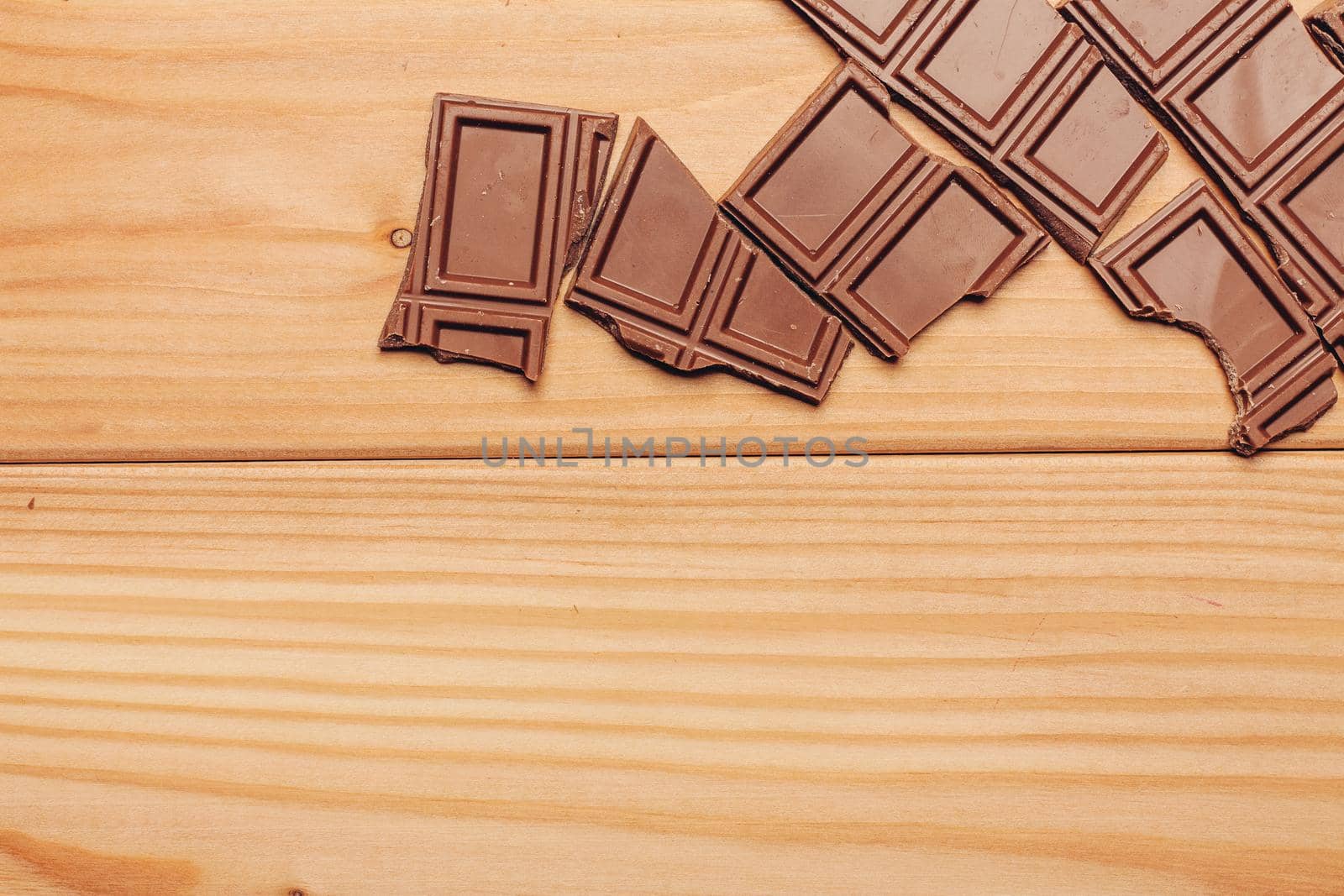 broken brown chocolate bar and background image texture top view. High quality photo