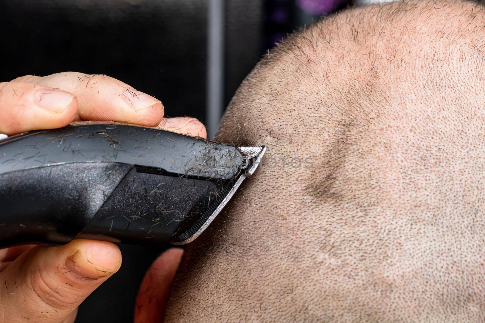 Man shaving or trimming his hair using a hair clipper