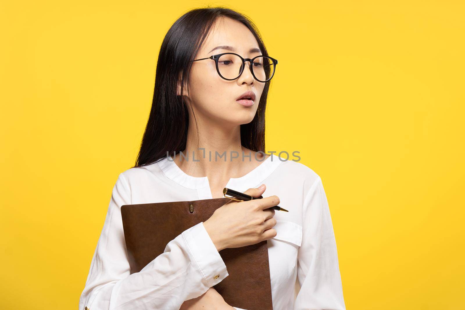 asian woman with notebook in hand learning student yellow background. High quality photo