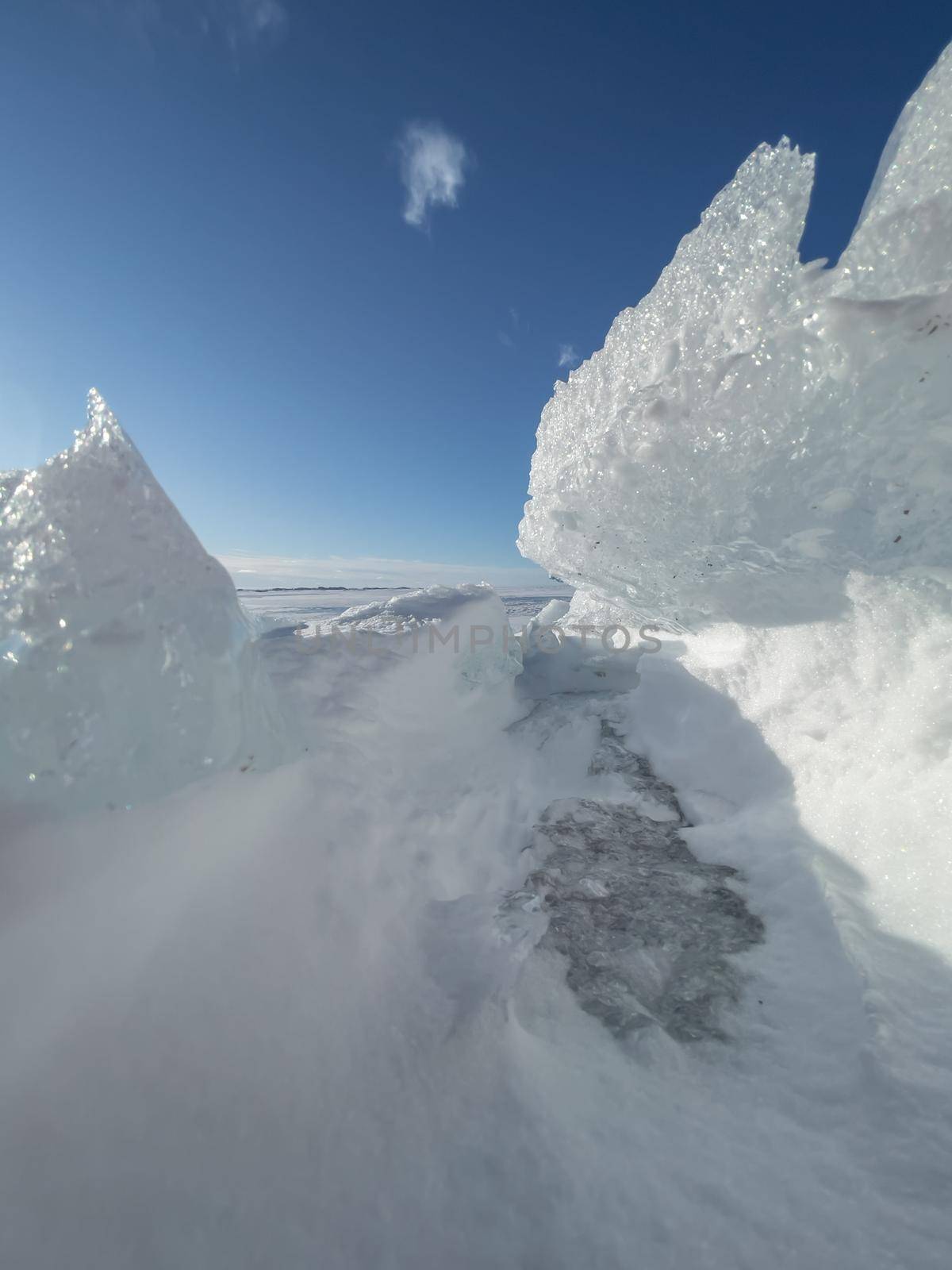 Ice slopes in sunny winter day, transparent ice of blue color, purely blue sky, long shadows, a pure snow-covered virgin soil, snow barkhans, . High quality photo