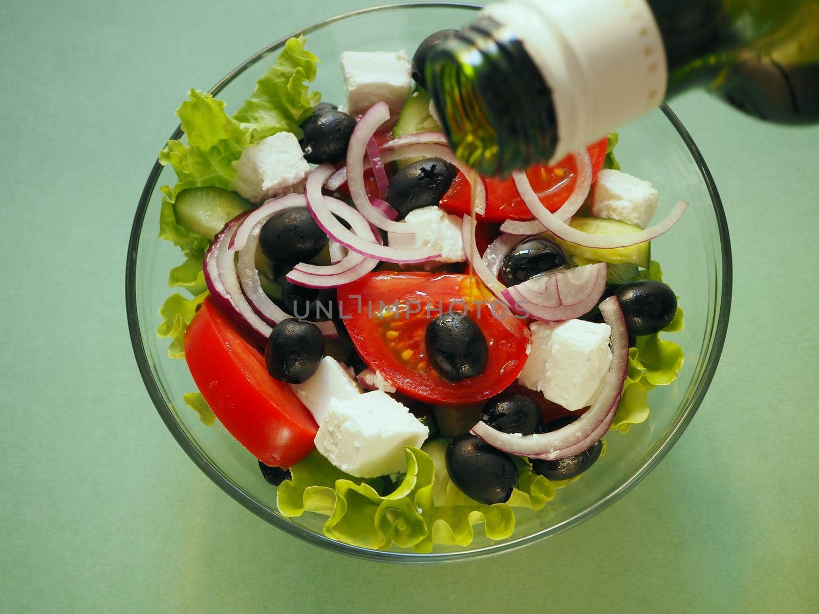 Greek fresh vegetable salad with feta cheese and olive oil in a bowl. Close-up, high-quality photo.