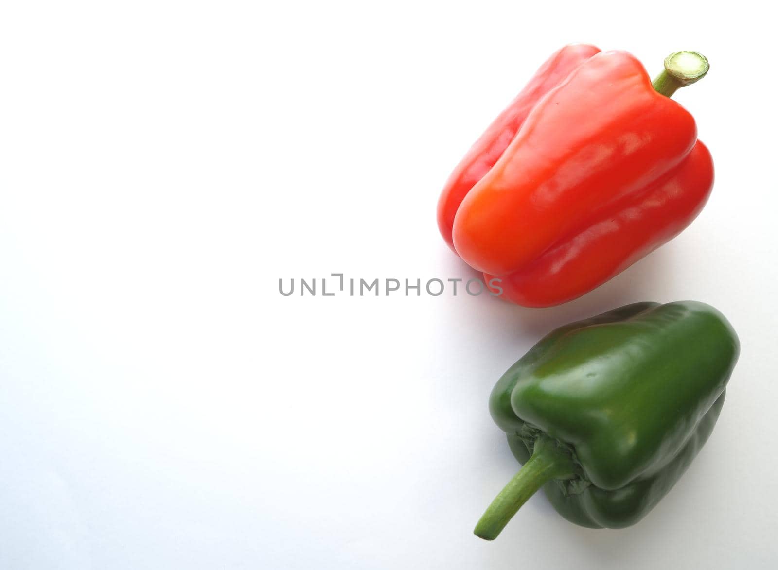 Ripe bell pepper, red, green, close-up on a white background.