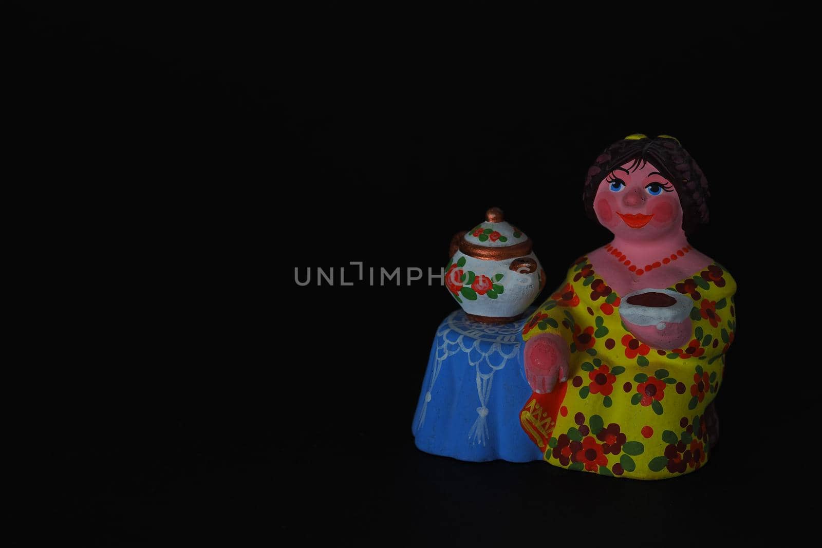 Ceramic figurines. A woman with a kettle, a samovar. Tea party. Close-up.