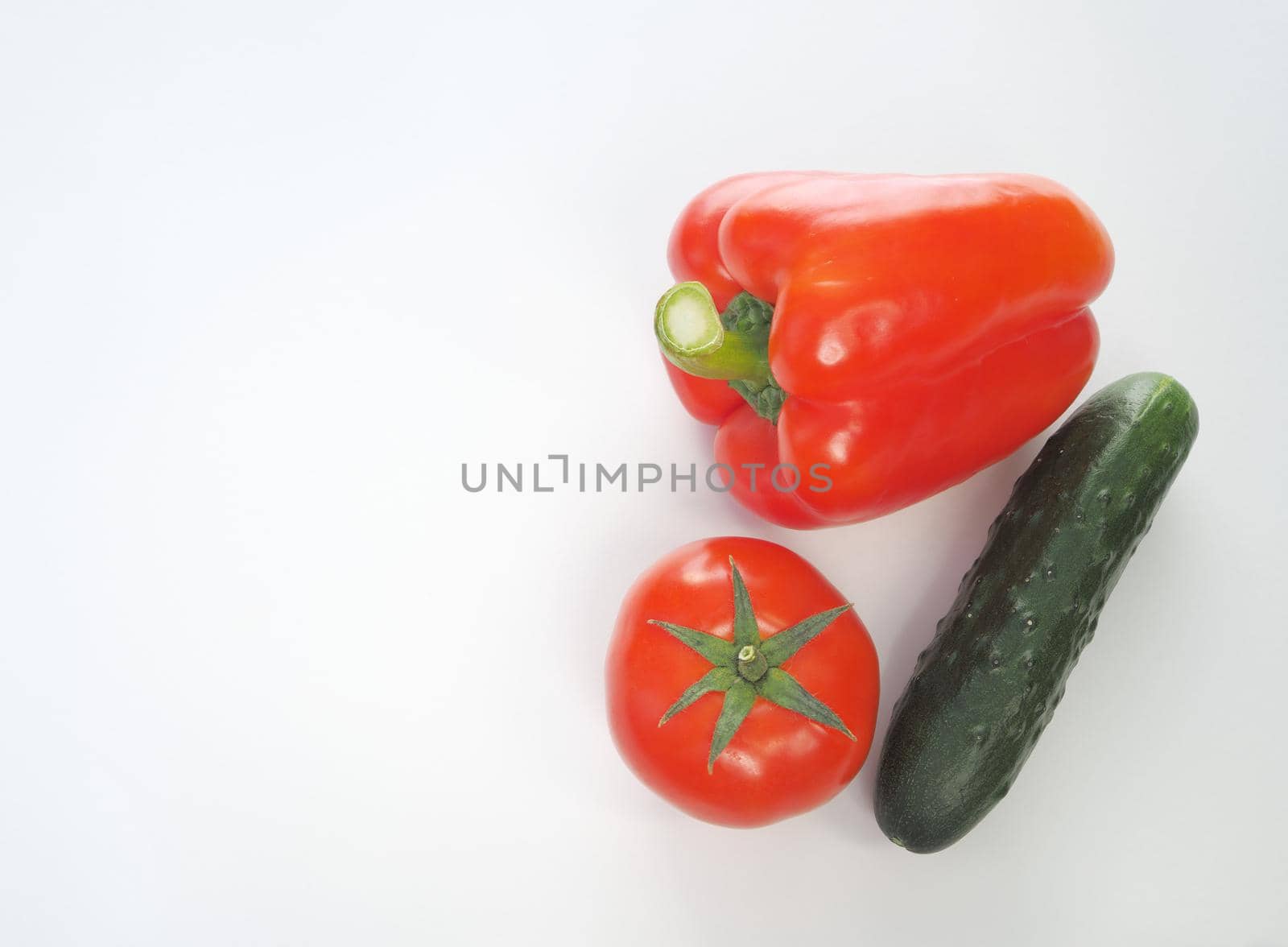 Fresh vegetables. Red tomato, bell pepper, and cucumber. Big plan on a white background.