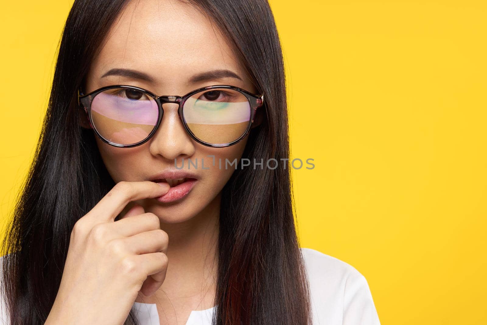 attractive woman asian appearance glasses close-up yellow background glamor. High quality photo