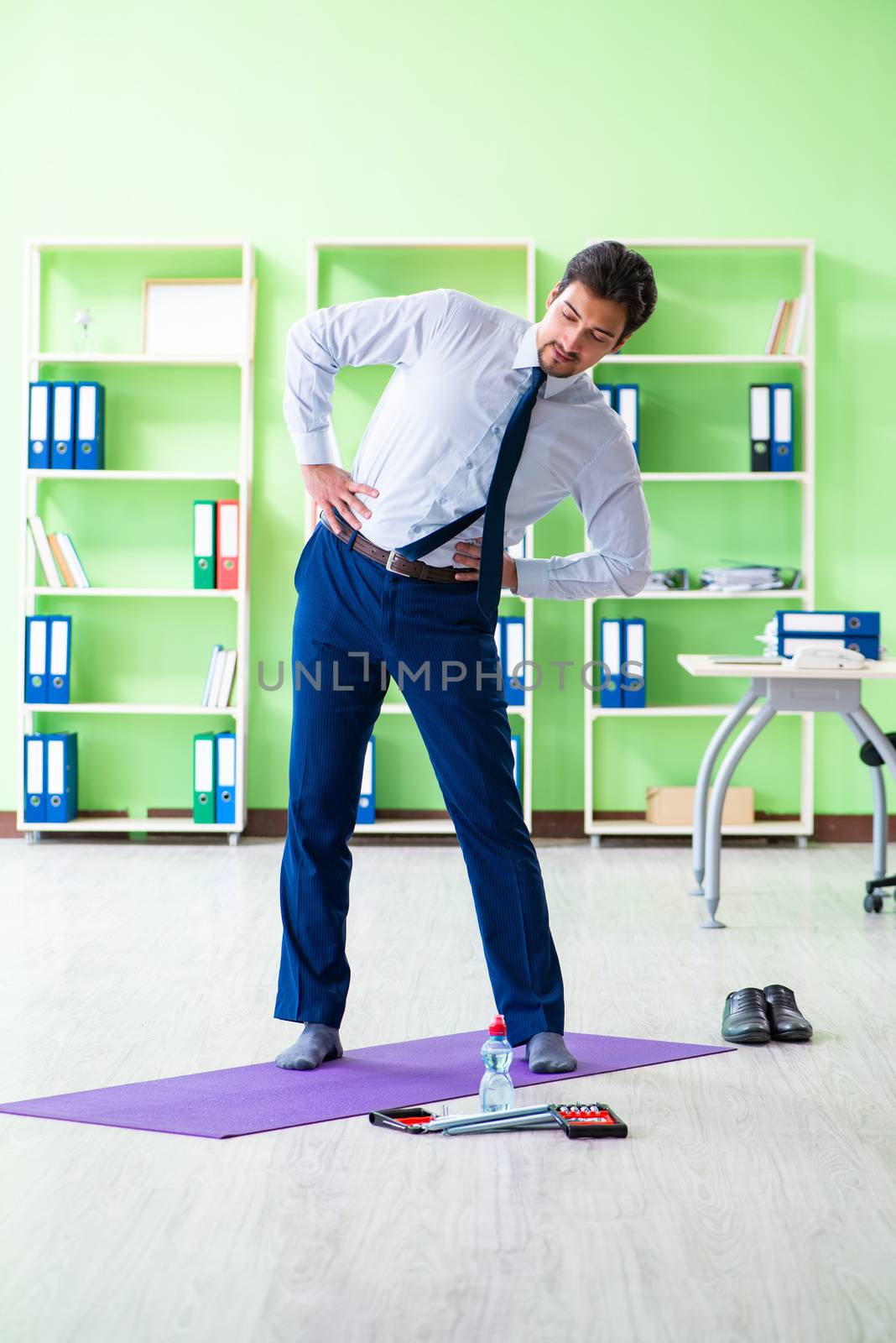 Employee doing exercises during break at work by Elnur