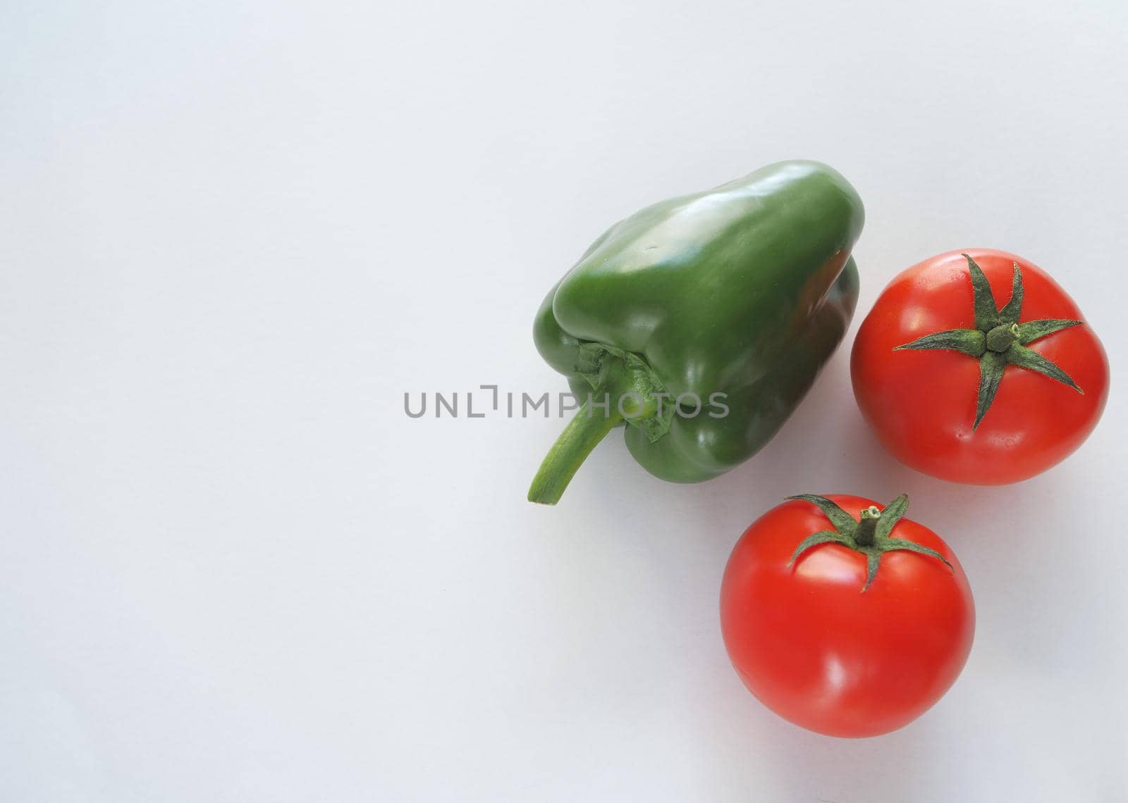 Fresh vegetables. Red tomato, bell pepper, and cucumber. Big plan on a white background.