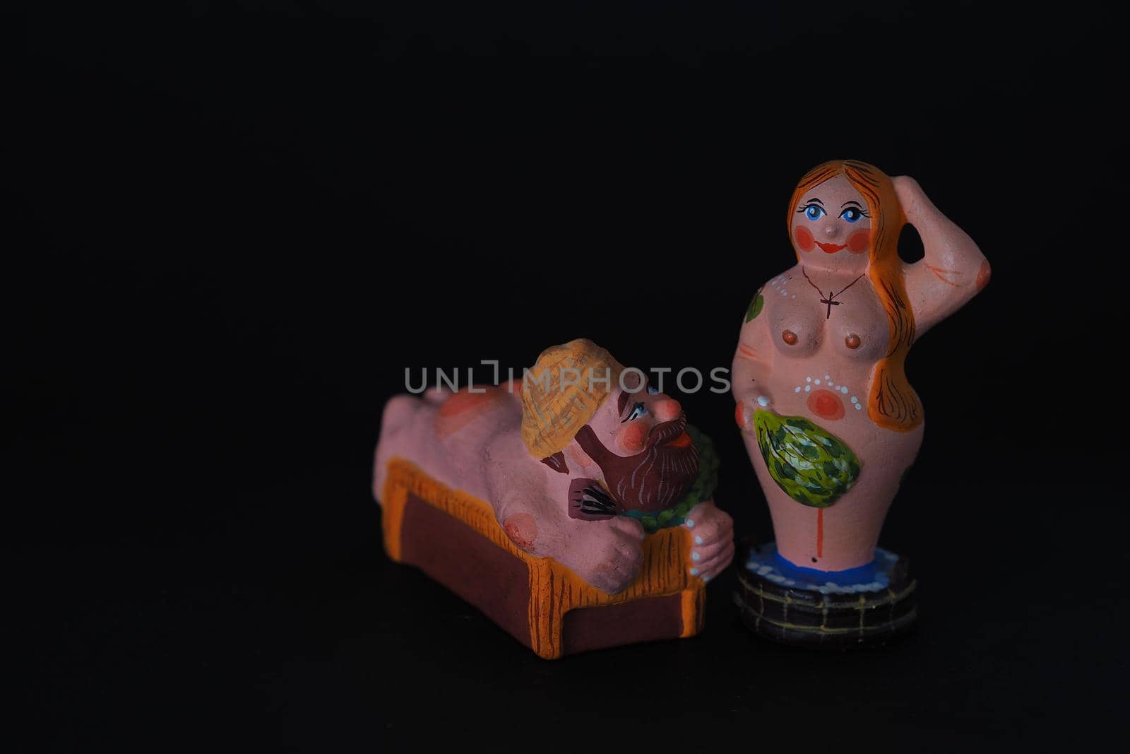 Funny figurines of plaster, clay and ceramics. Bath. The people in the steam room. It's a macro- Black background.