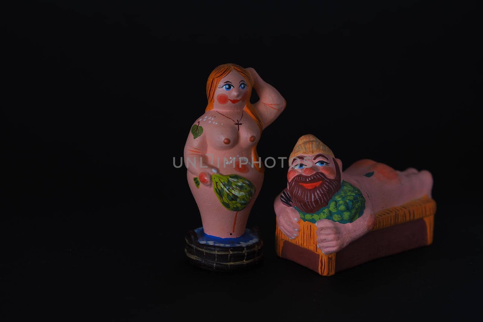 Funny figurines of plaster, clay and ceramics. Bath. The people in the steam room. It's a macro- Black background.