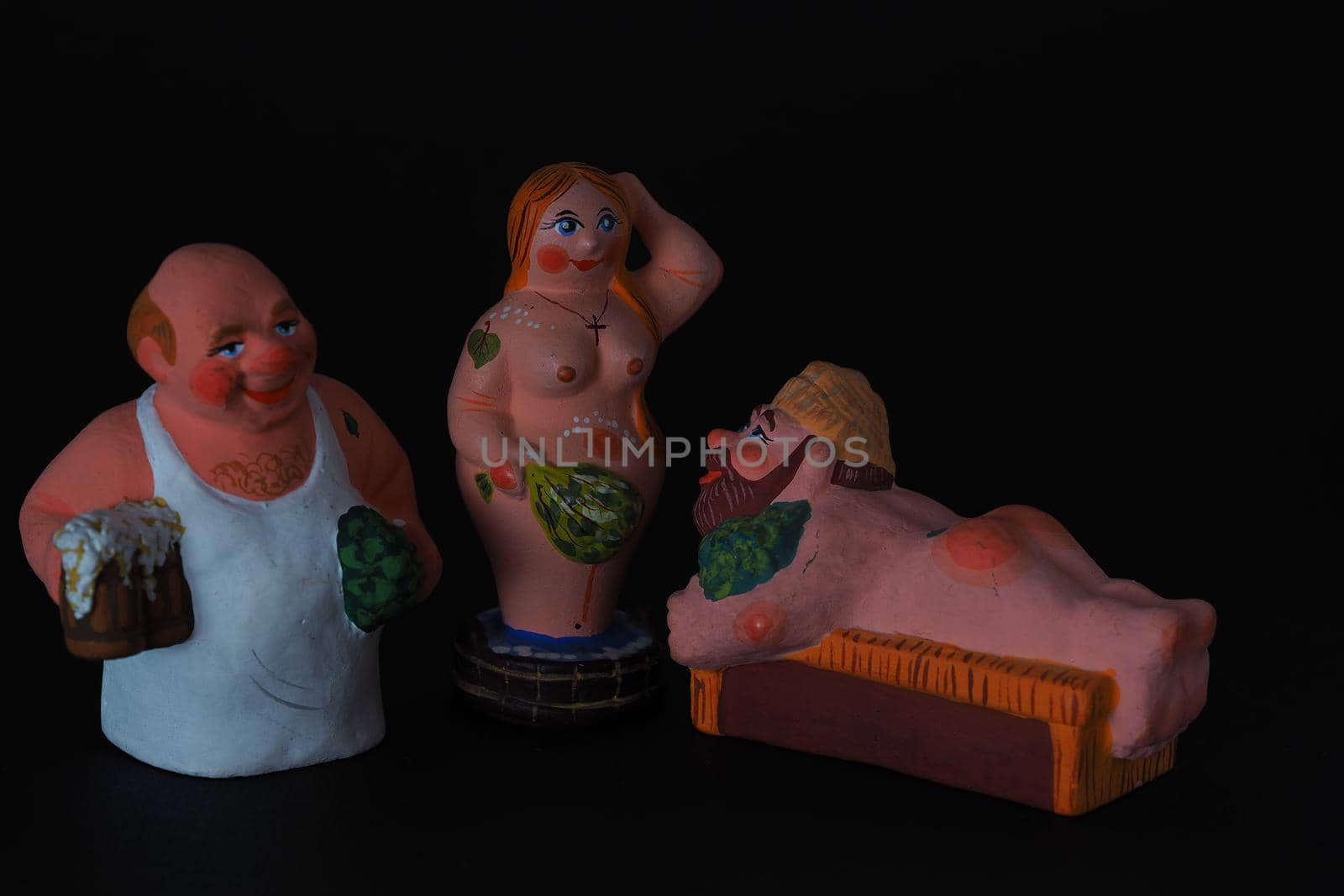 Funny figurines of plaster, clay and ceramics. Bath. The people in the steam room. It's a macro- Black background.