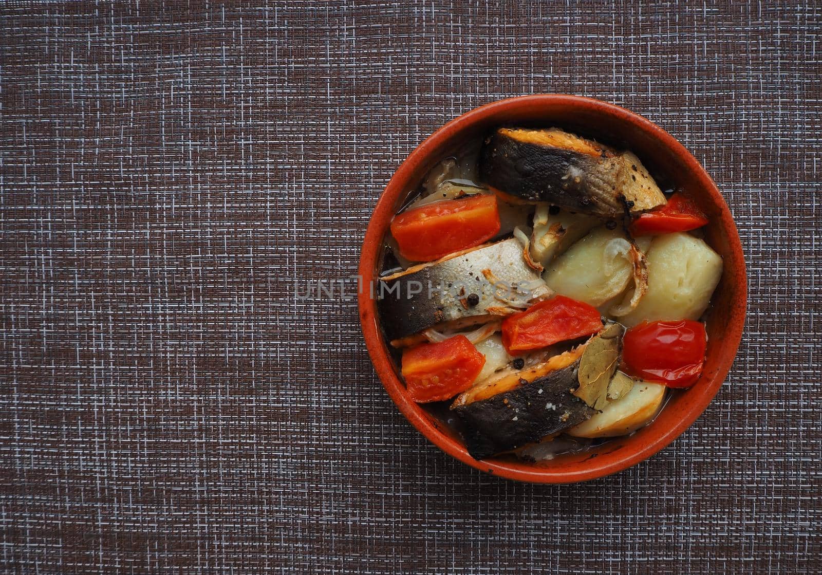 A dish of fish with vegetables baked in the oven. Close-up.