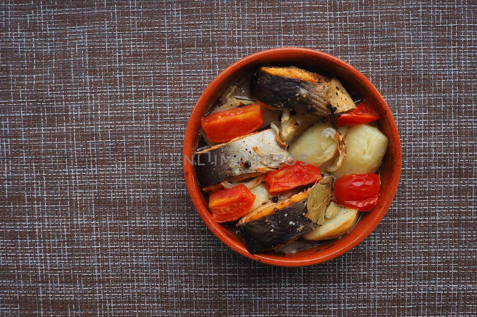 A dish of fish with vegetables baked in the oven. Close-up.