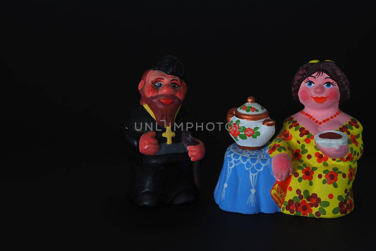 Ceramic figurines. A woman with a kettle, a samovar. Tea party. Close-up.