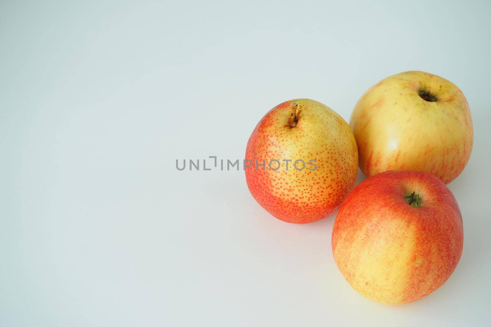 Ripe fruit. Two pears and an apple on a white background. Horizontal image. 