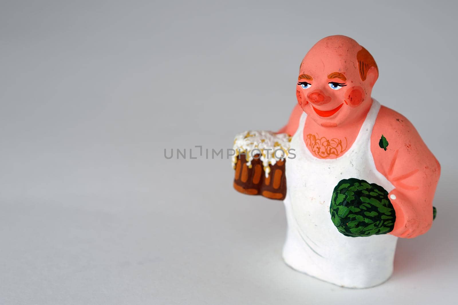 Funny figurines of ceramics, plaster and clay. A man in a bath with a broom. Close-up.