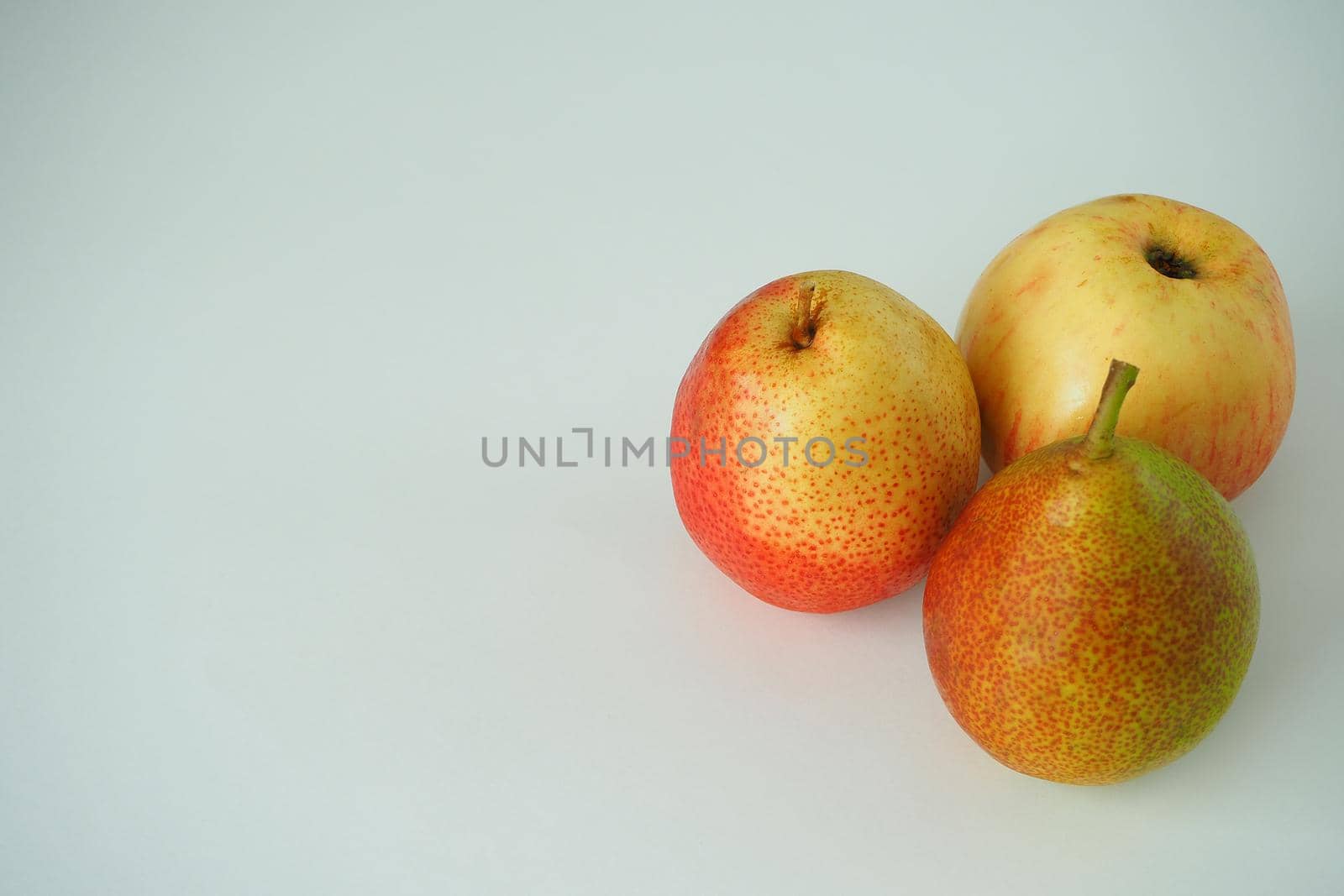 Ripe fruit. Two pears and an apple on a white background. by Olga26