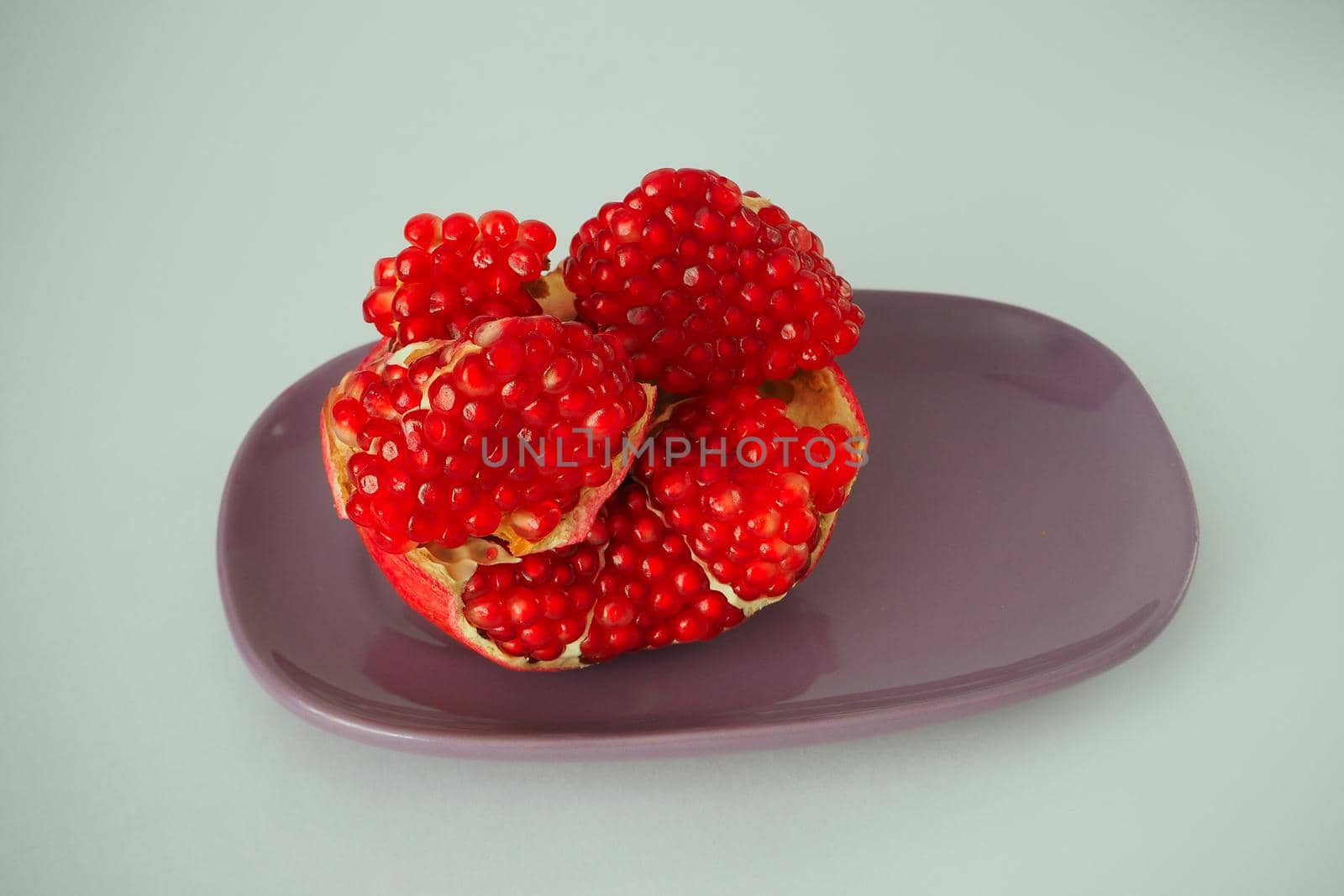 Ripe pomegranate. Red fruit with ripe grains. Isolated on a white background.