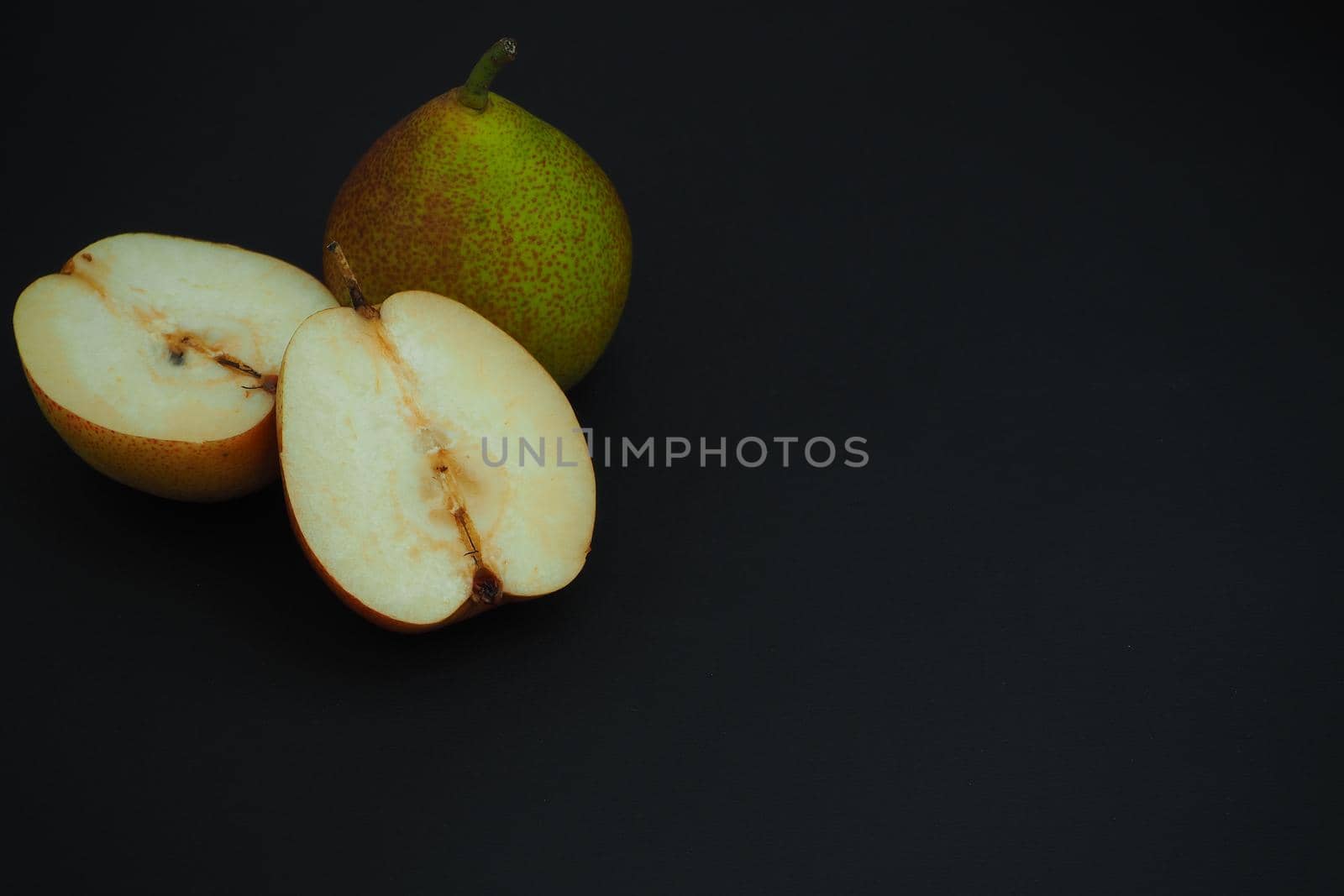 Ripe fruit, Pear cut into pieces. Black background.