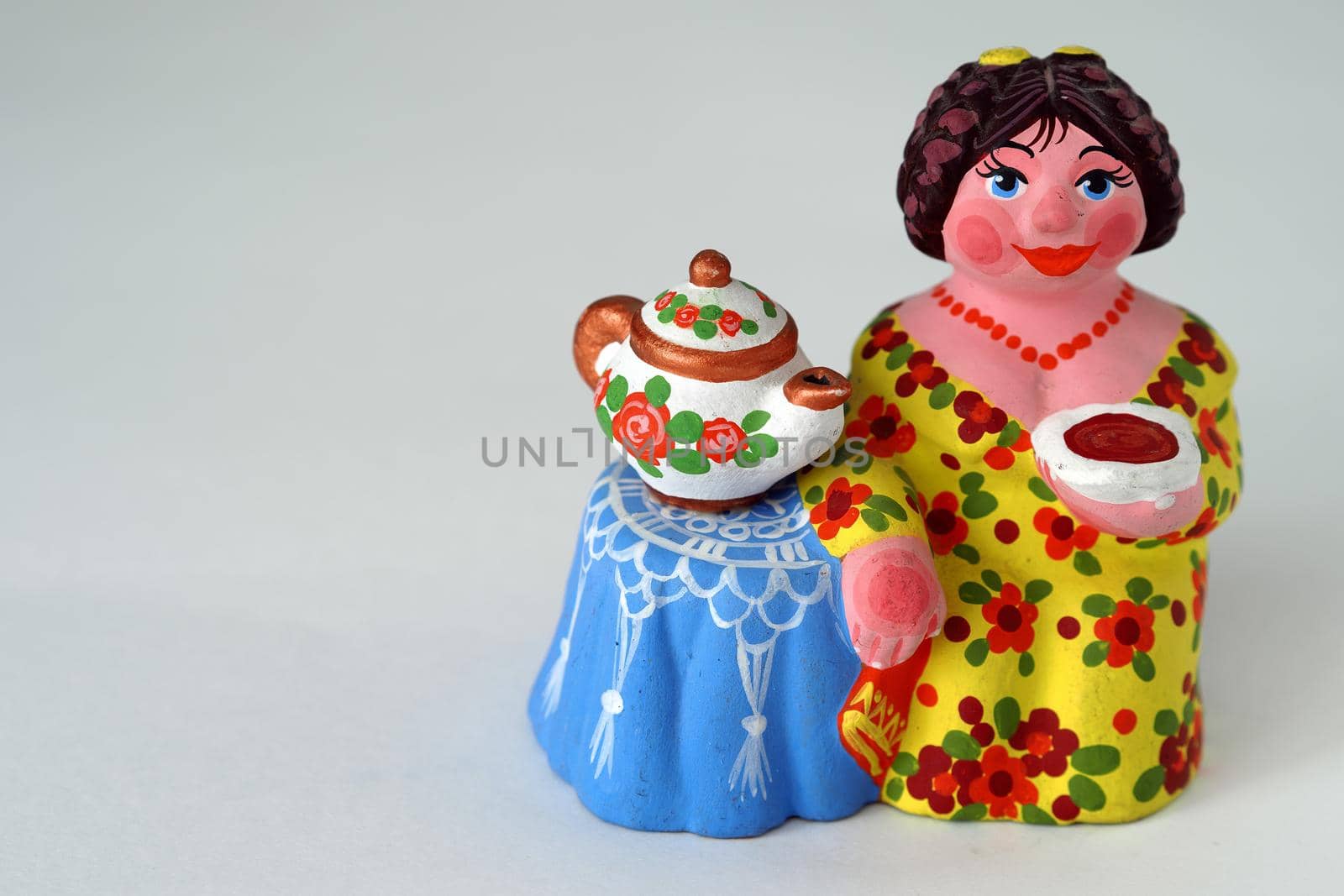 Ceramic figurines. A woman with a kettle, a samovar. Tea party. Close-up.