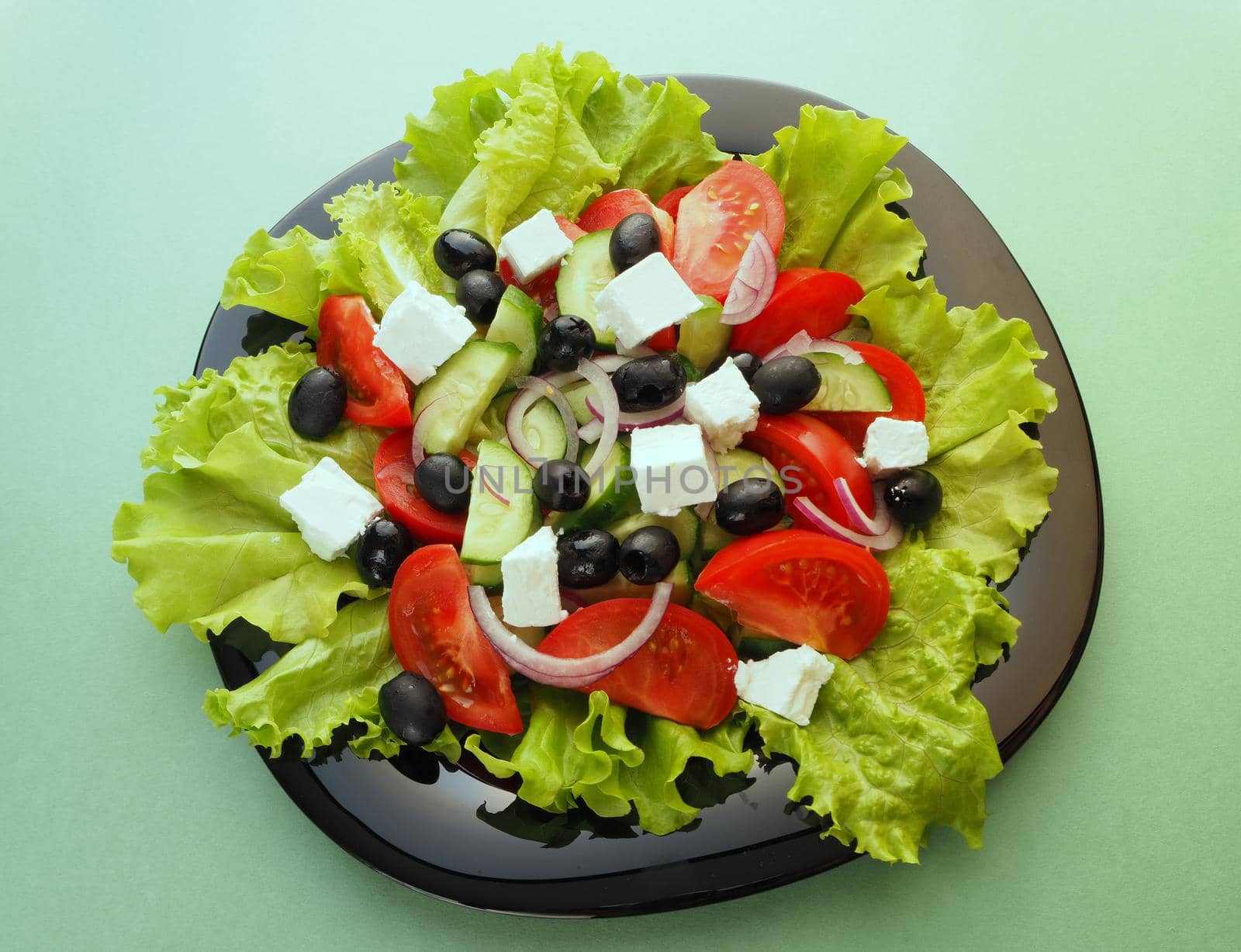 Greek fresh vegetable salad with feta cheese and olive oil in a bowl. Close-up, high-quality photo.