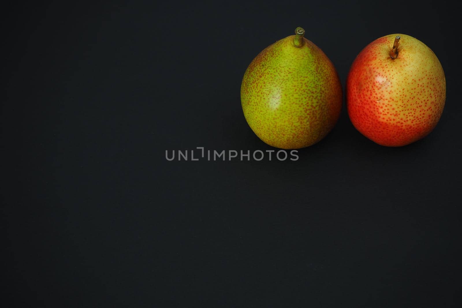 Two ripe pears on a black background. Beautiful fruit. by Olga26