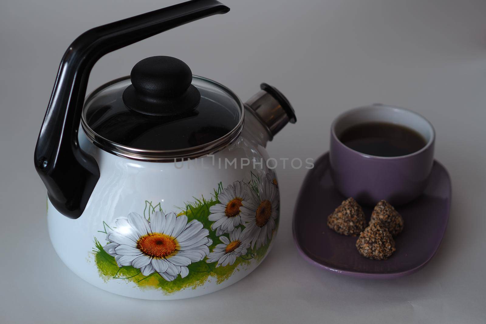 The kettle is enamelled, with a whistle, white. Close-up. 