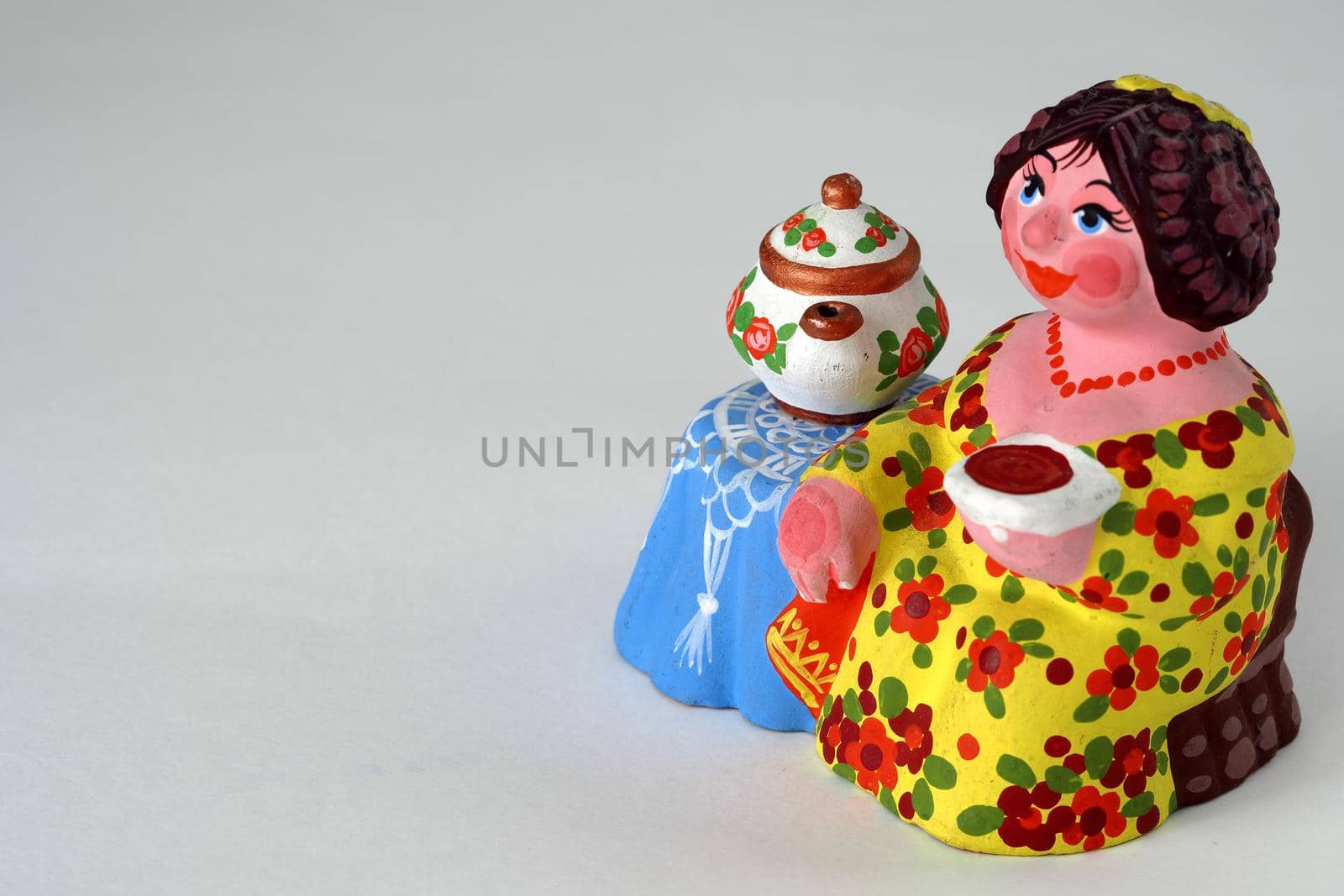 Ceramic figurines. A woman with a kettle, a samovar. Tea party. Close-up.