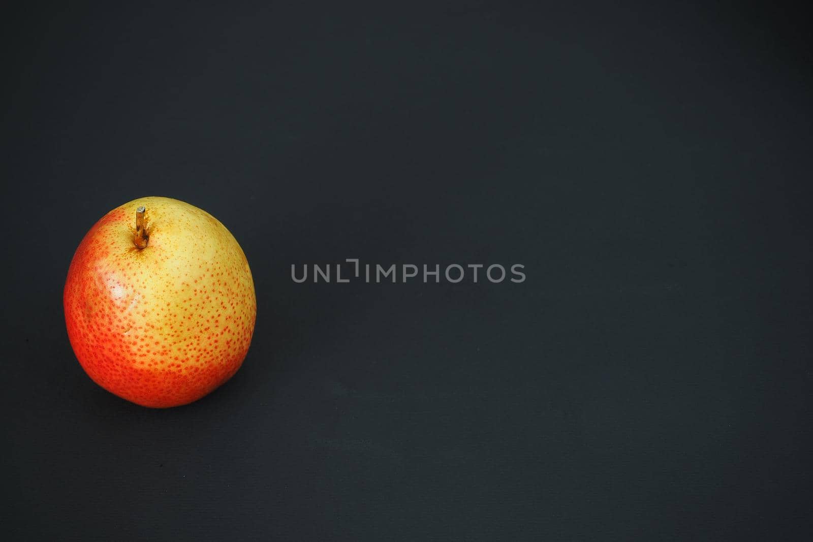 Ripe fruit. One pear on a black background.  by Olga26