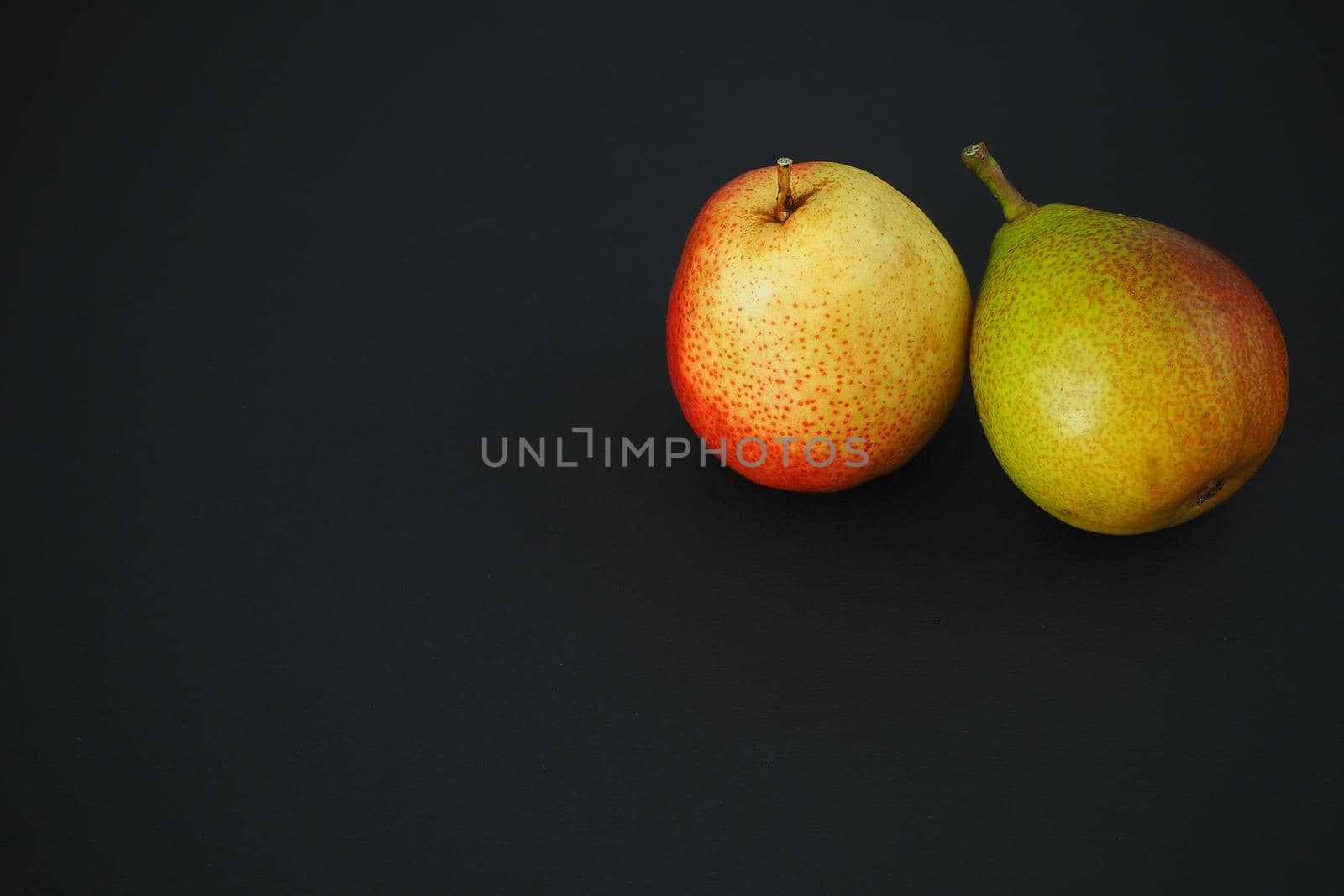 Ripe fruit. Two beautiful pears on a black background. Top right.