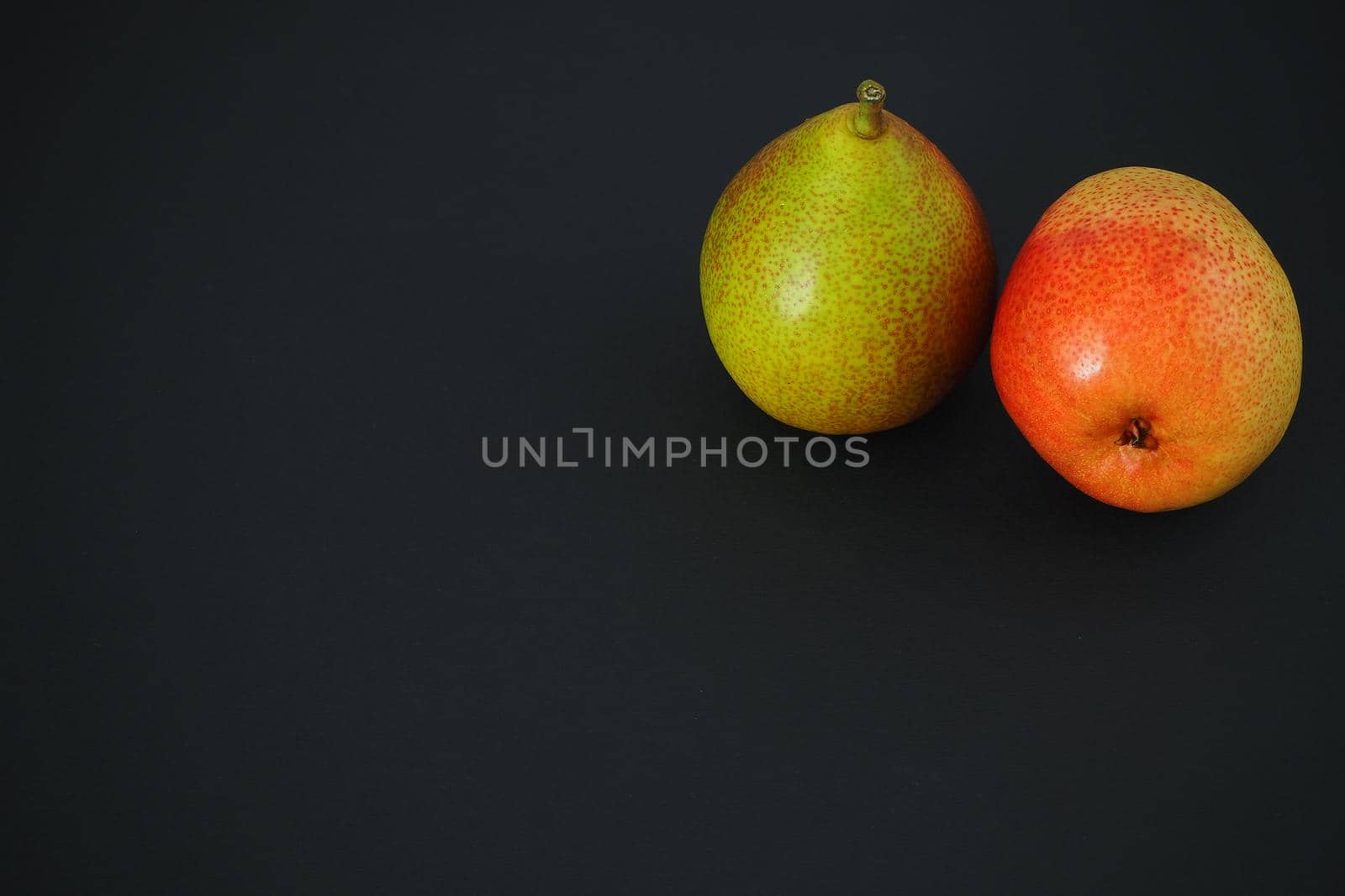 Two ripe pears on a black background. Beautiful fruit. by Olga26