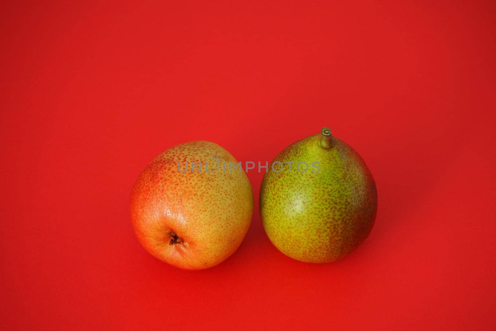 Ripe pears. Beautiful fruit on a red background. Bright image, horizontal.