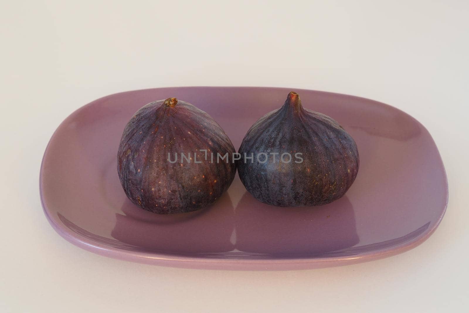 The figs are purple on an oval platter. by Olga26