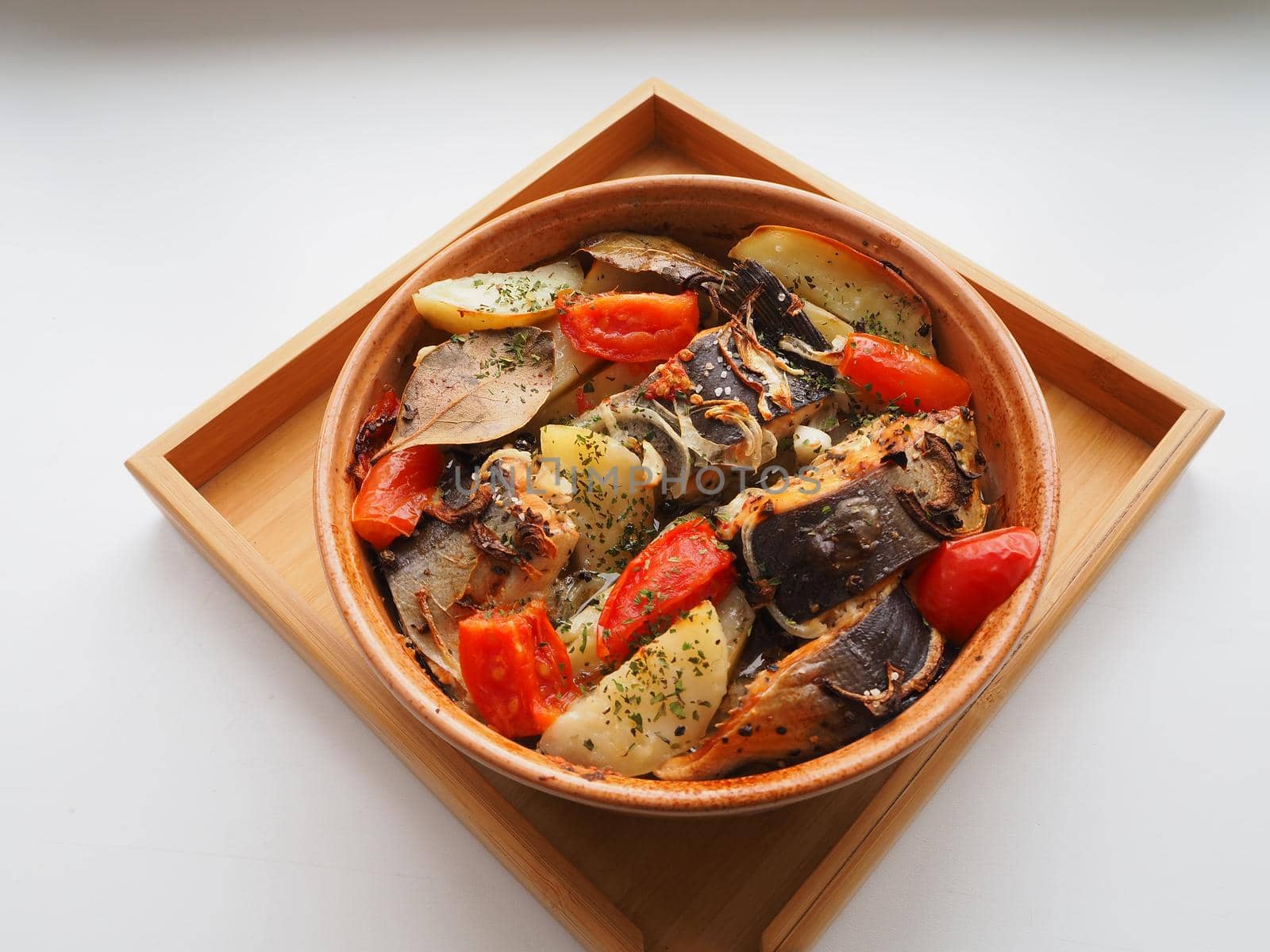 A dish of fish with vegetables baked in the oven. Close-up.