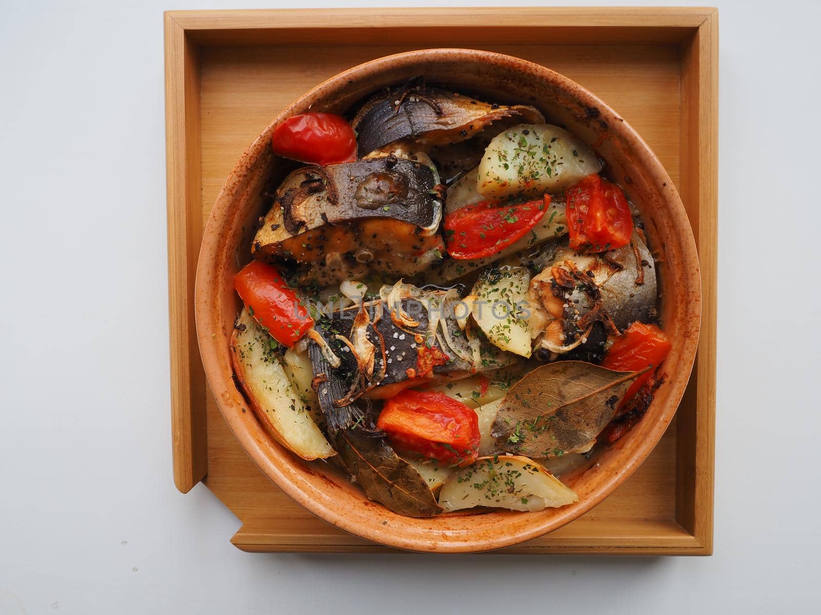 A dish of fish with vegetables baked in the oven. Close-up.