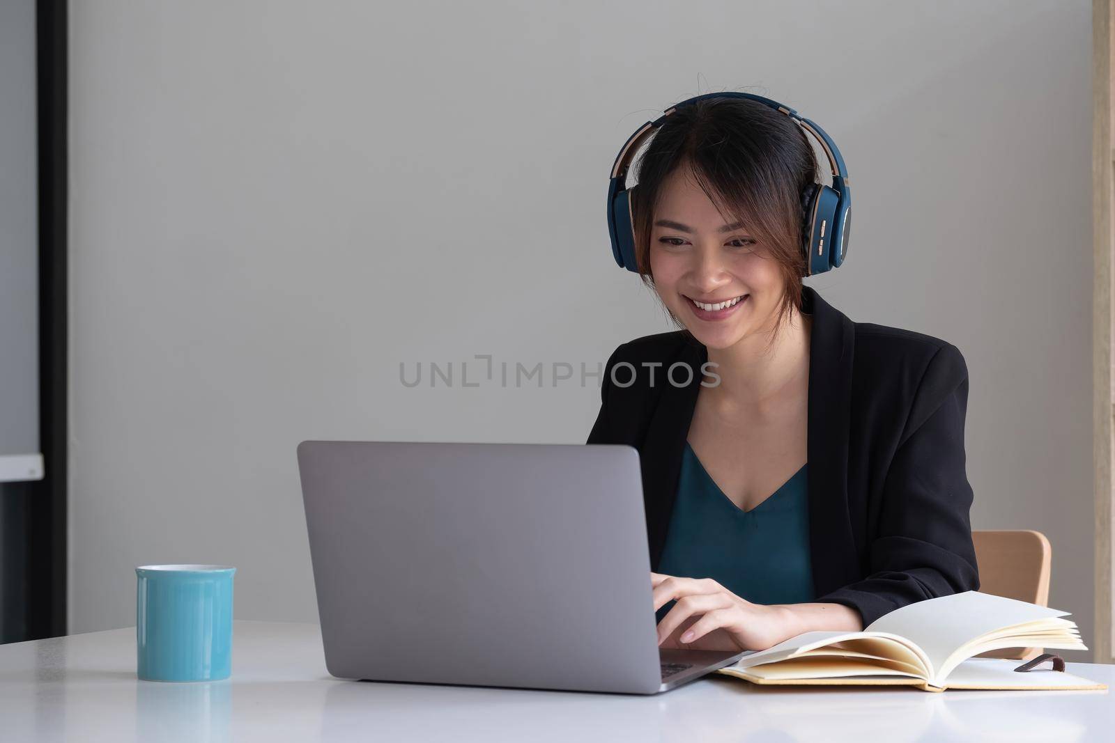 Happy asian woman wear headset laugh using laptop video stream conference call teach online, happy ethnic girl student gamer tutor have fun watch webinar web cam education entertainment concept by nateemee