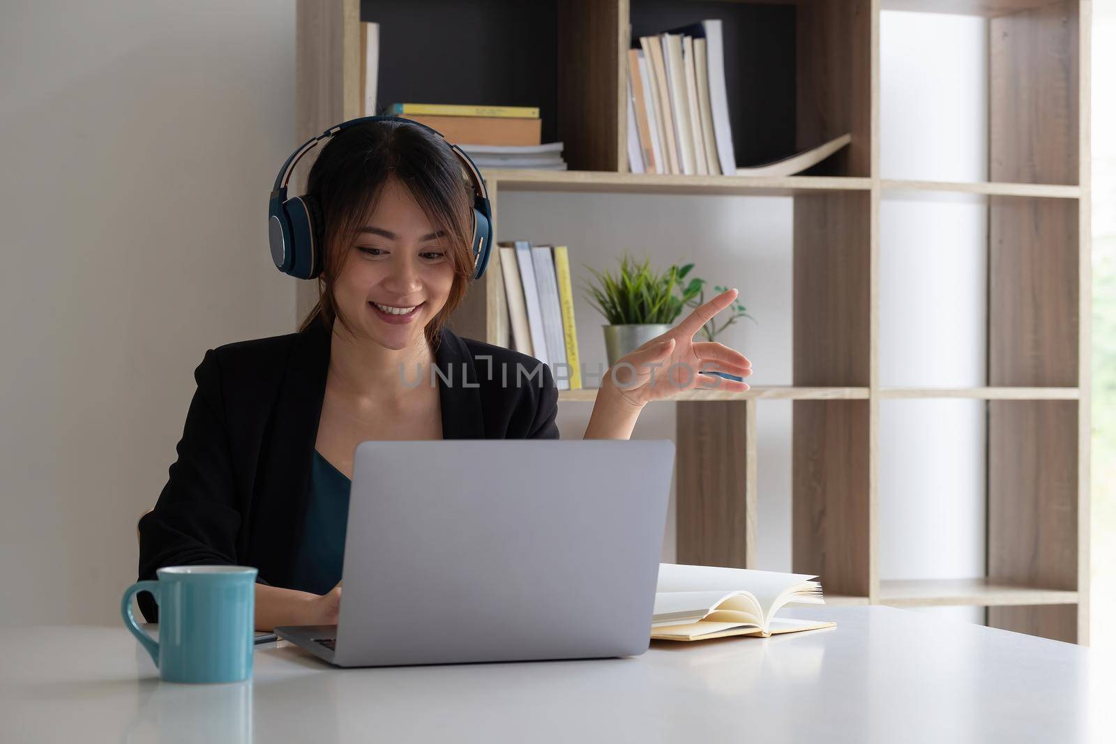 Happy asian woman wear headset laugh using laptop video stream conference call teach online, happy ethnic girl student gamer tutor have fun watch webinar web cam education entertainment concept by nateemee