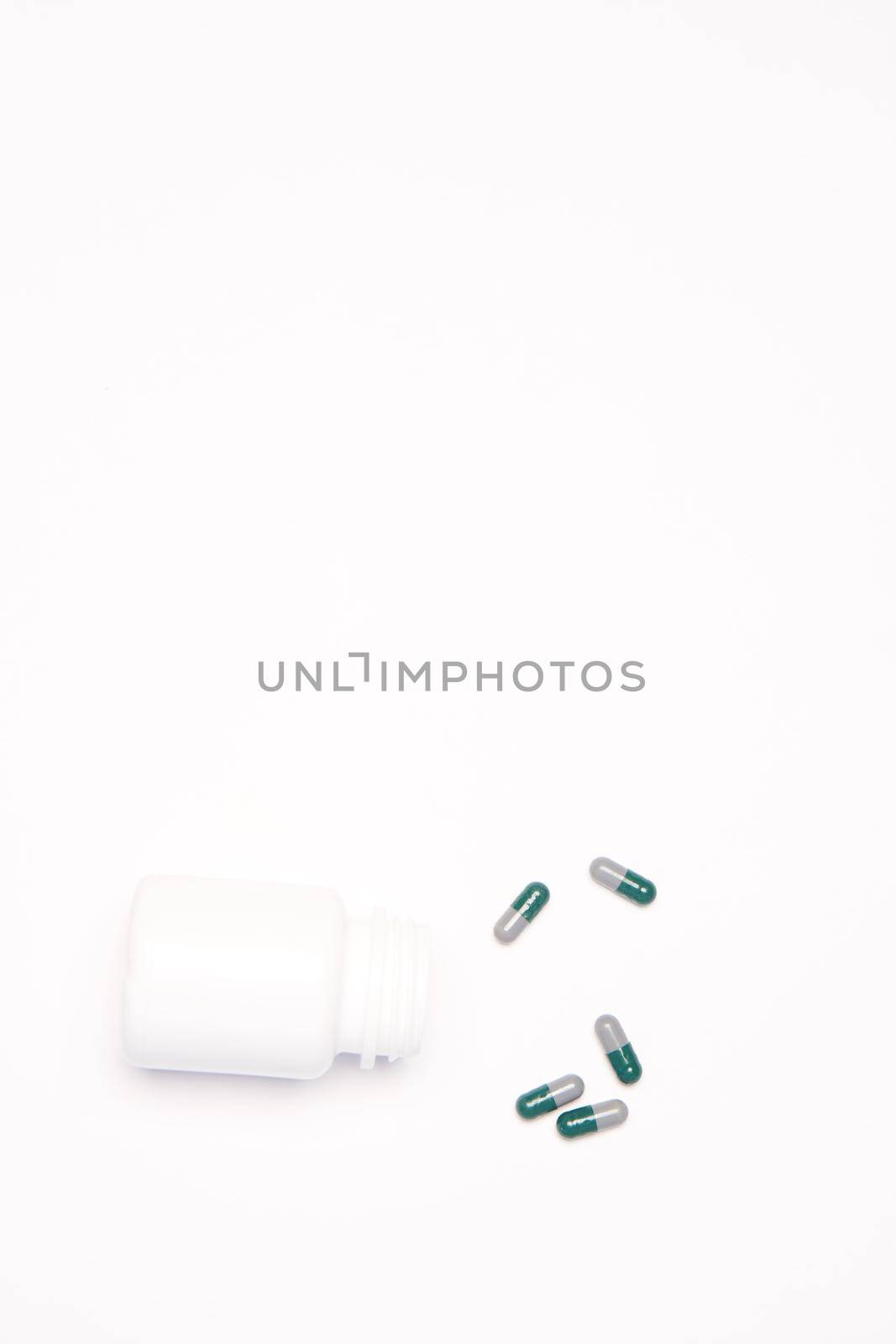A jar with multi-colored pills arranged in a certain order on a Light background Copy Space top view. High quality photo