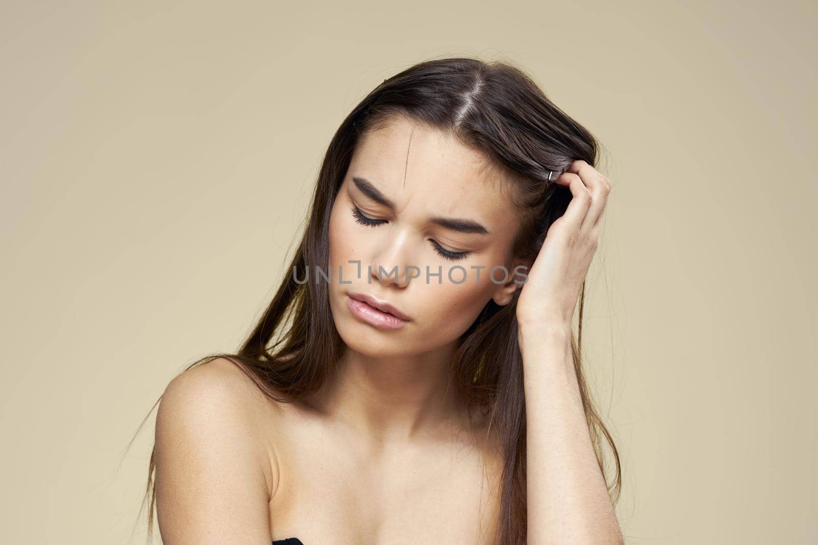 Pretty woman naked shoulders long hair body care beige background. High quality photo