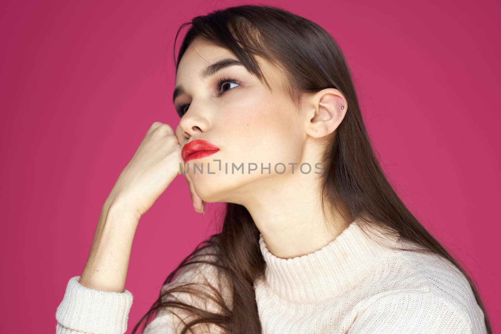 Woman with red lips bright makeup white blouse long hair pink background. High quality photo