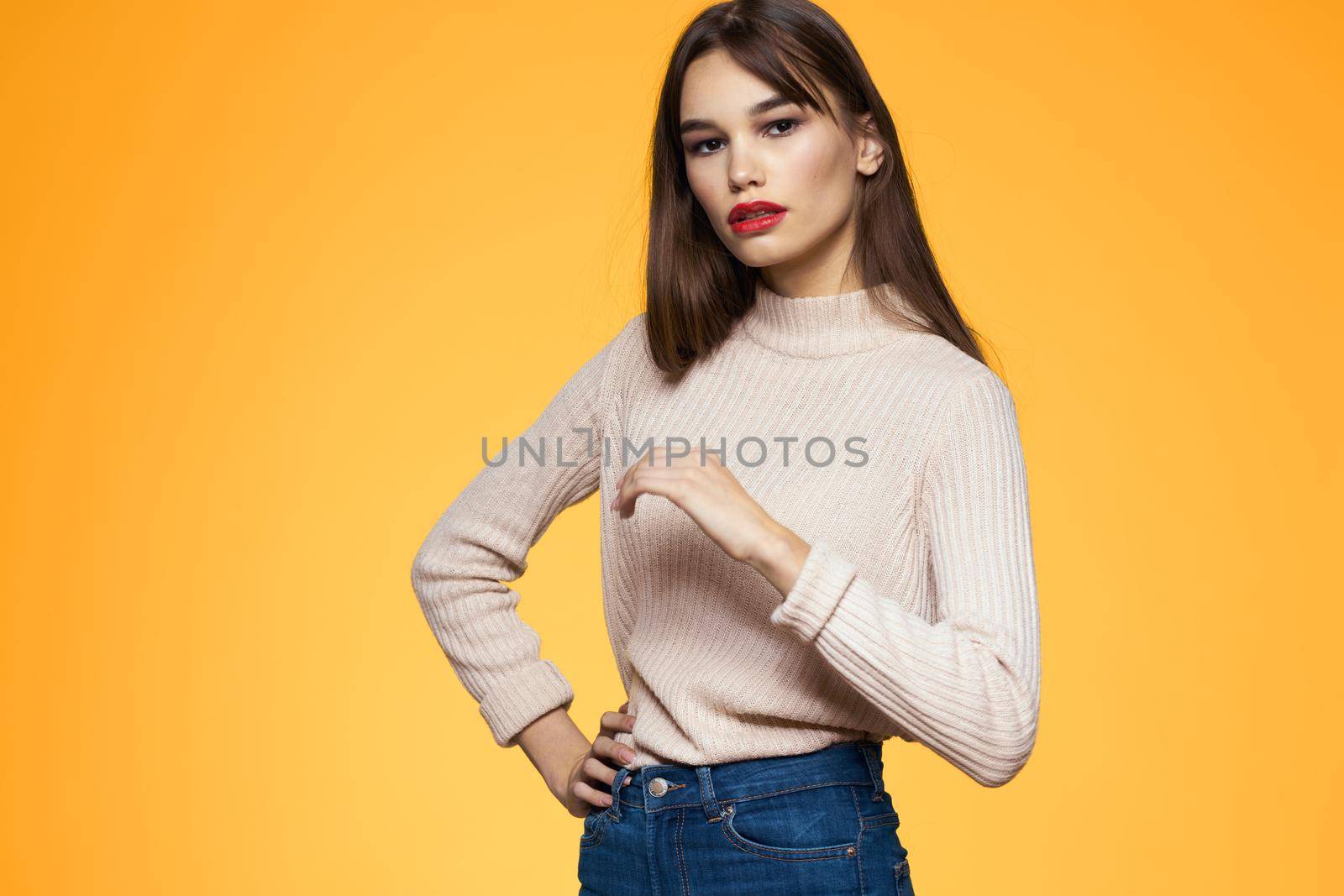 Cute brunette red lips fashionable clothes studio yellow background. High quality photo