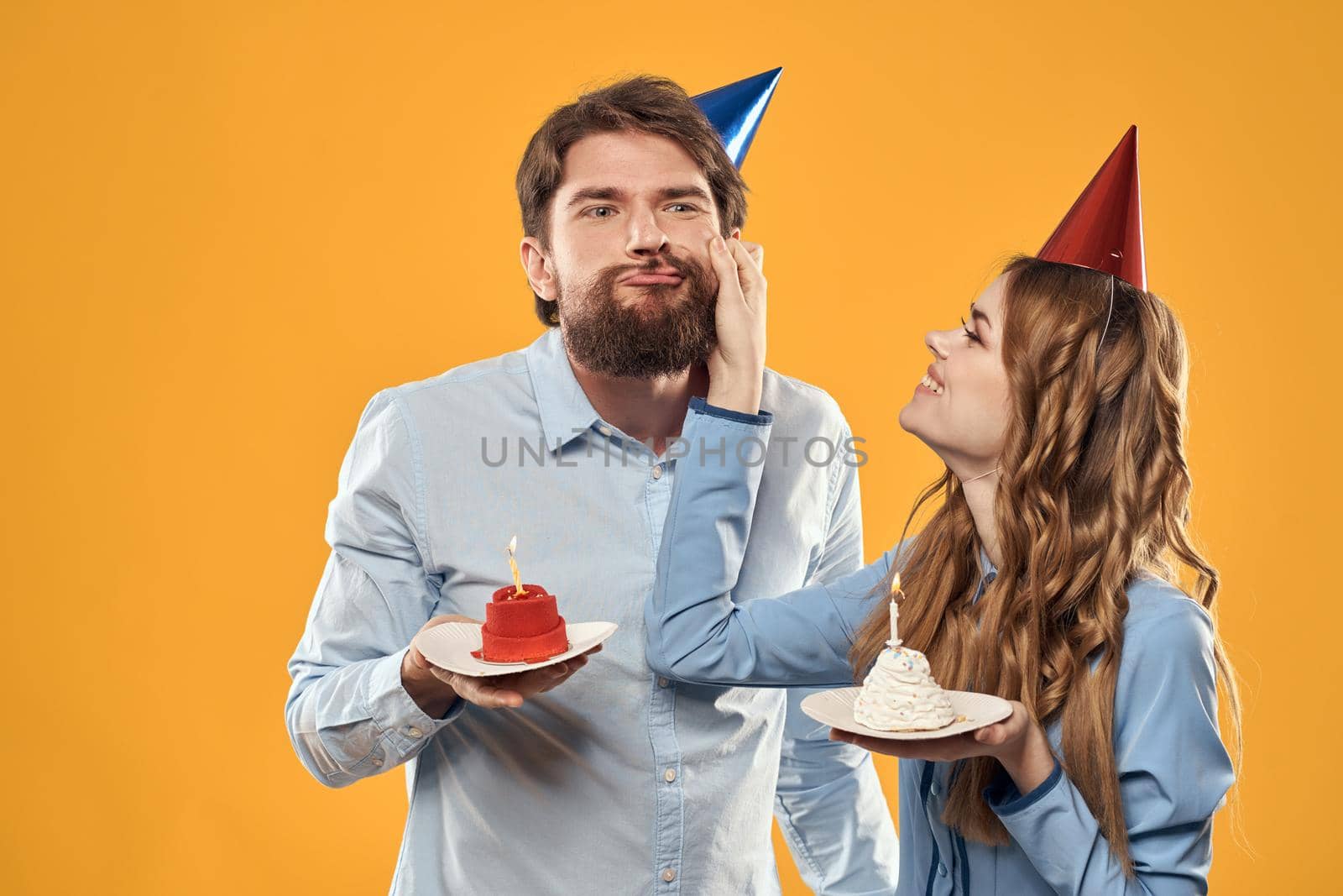Birthday party man and woman fun yellow background cap holiday. High quality photo