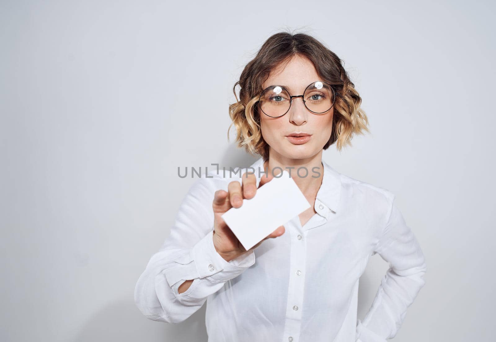 Business woman with a business card on a light background work advertisement. High quality photo