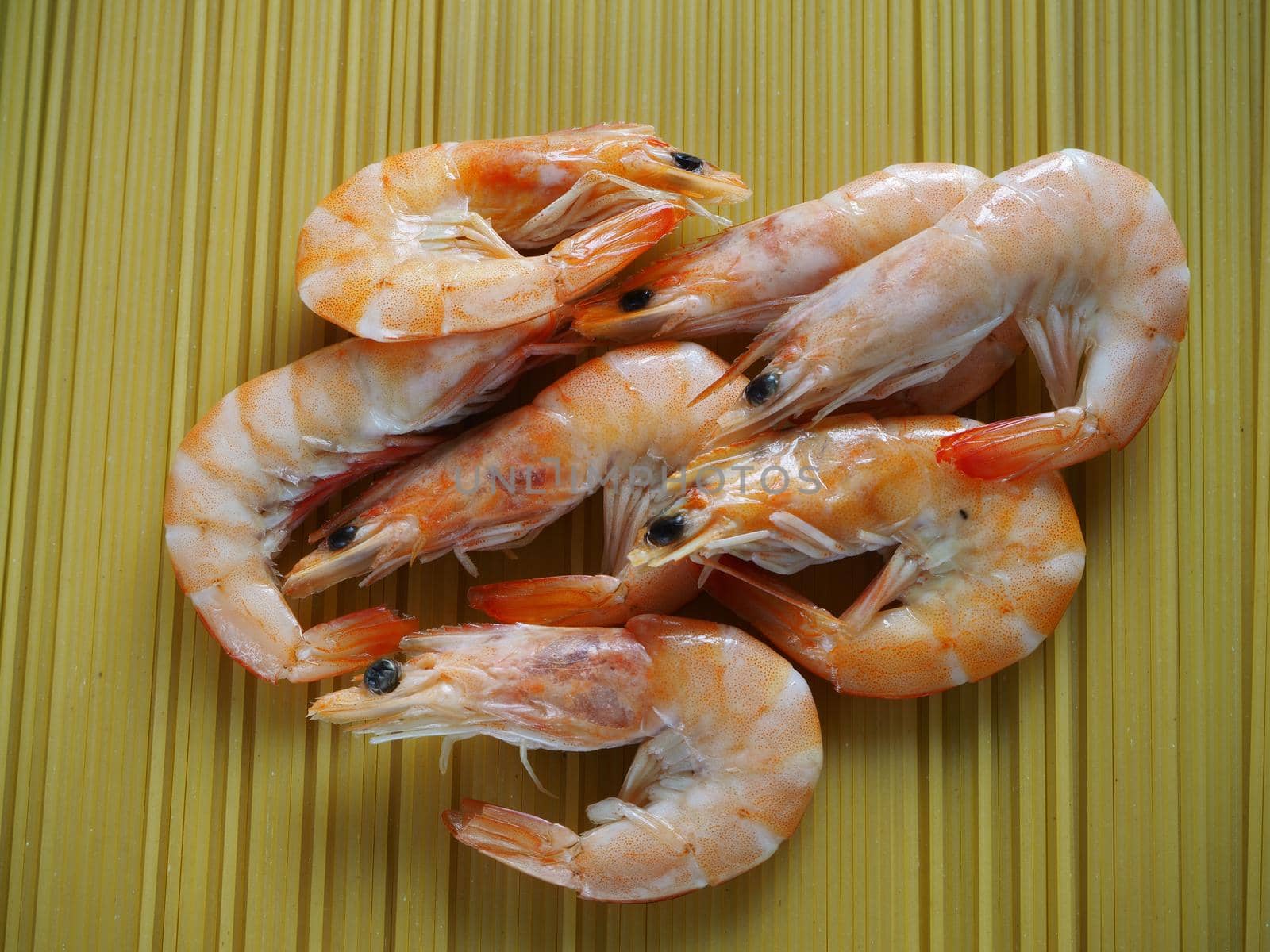 Large prawns with spices and spaghetti. Prawns with dill and pepper close-up. Bright background.