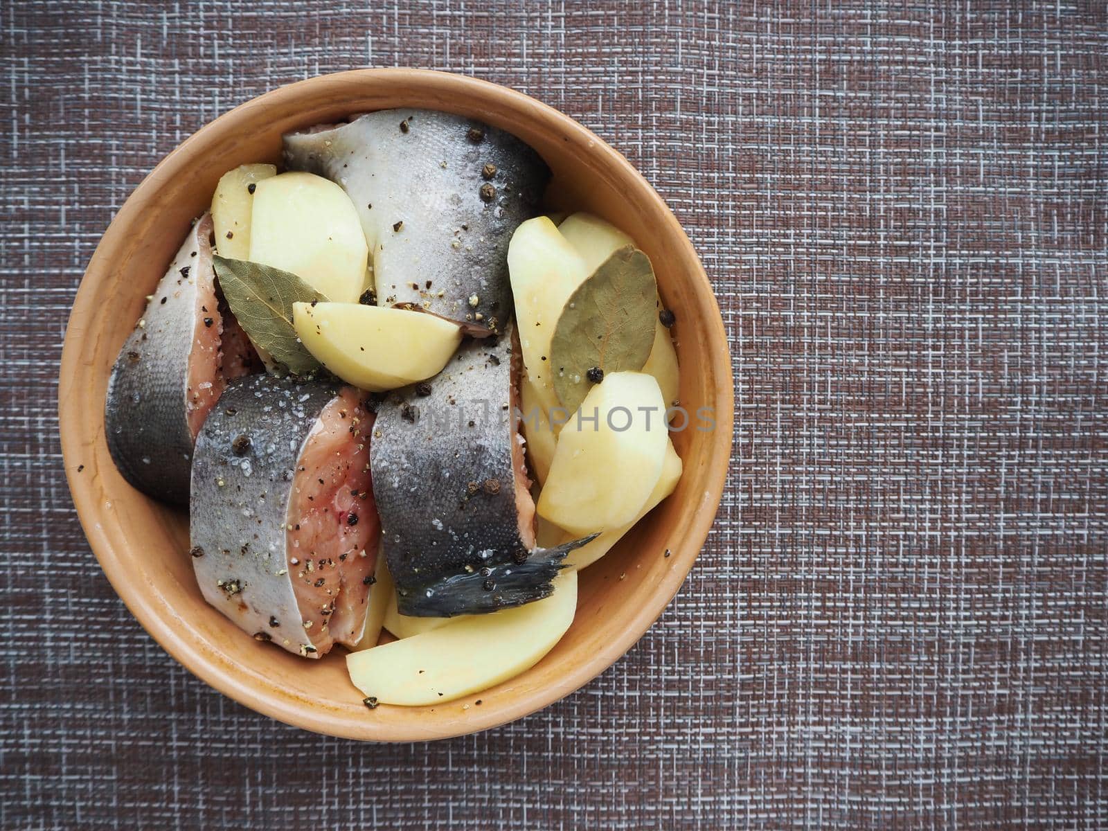 The dish of fish with vegetables is raw. Close-up.