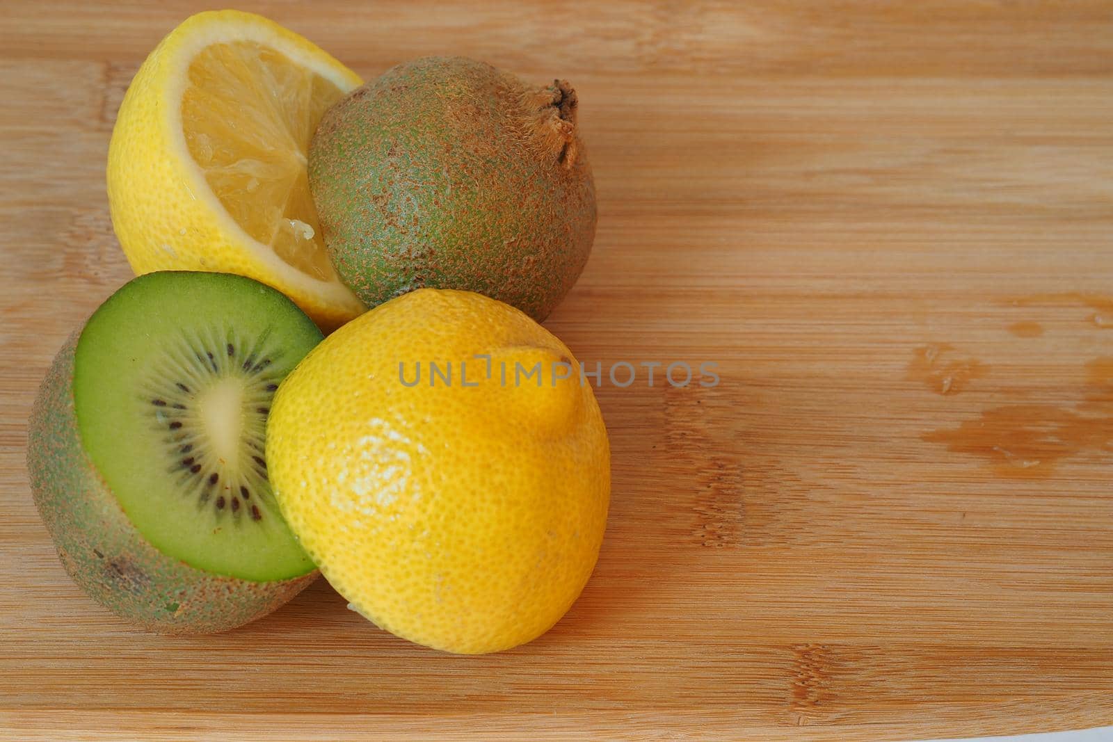 Citrus. Kiwi and lemon cut in half. A wooden background. Close-up. by Olga26