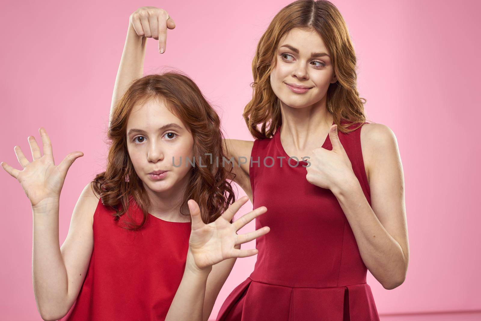 Mom and daughter fun communication family joy pink background cropped view. High quality photo